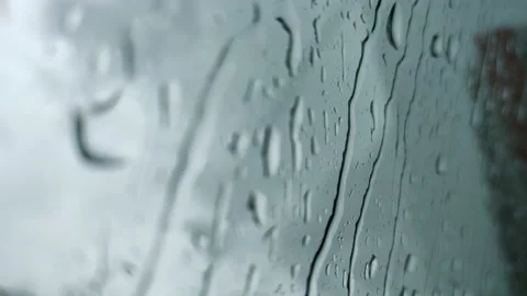 Water drops falling down on window car glass. rain drops on blue window. Water Stock Footage 143749794