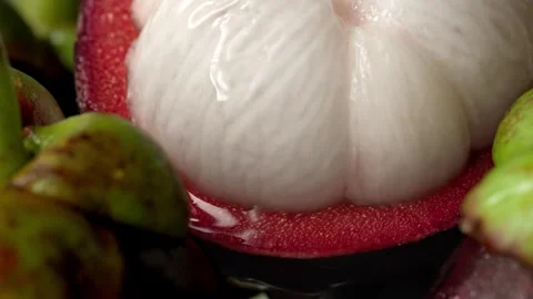 Water drops falling from a half-opened fresh mangosteen Stock Footage 318376969