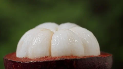 Water drops falling from half opened fresh mangosteen, macro shot of mangosteen Stockbeeldmateriaal 318376994