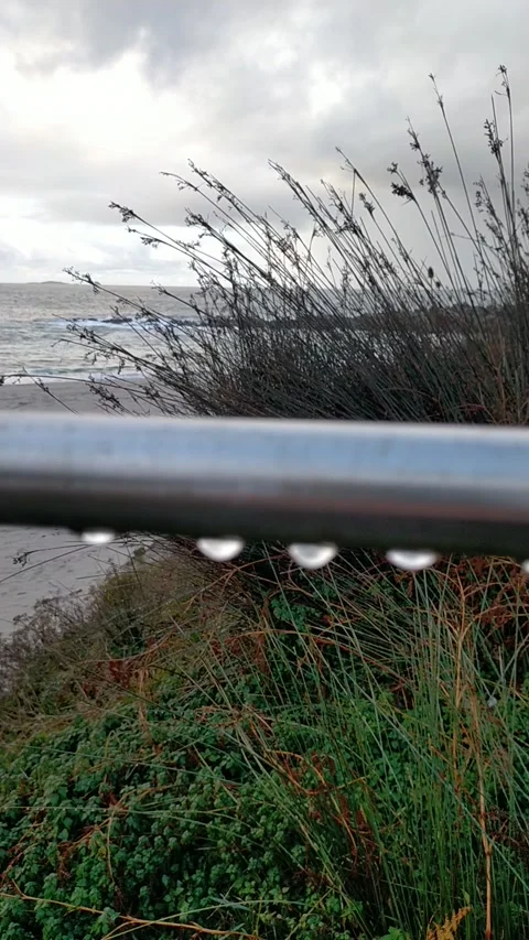 Water drops falling from pipe onto sandy beach Video stock 327190694