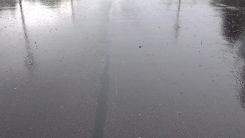 Water drops falling into puddle on asphalt. Stock Footage 98304763