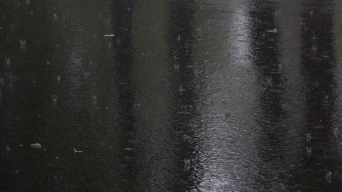 Water drops falling into puddle on asphalt. 動画素材 98496356