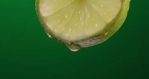Water drops falling from pulp of juicy green lime. Close up of fresh citrus Stock Footage 180676884
