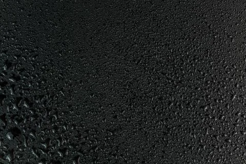 Water drops on flat black rubber surface macro background Foto stock