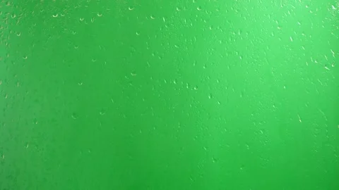 Water drops flow down the glass on a green background. Stock Footage 139702520