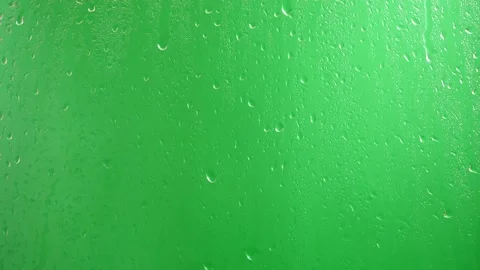 Water drops flow down the glass on a green background. Stock Footage 139702973