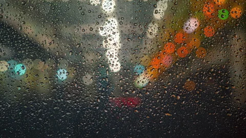 The water drops flow down the window on a background of city lights. time lapse Stock Footage 130897532