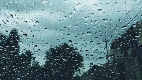 Water Drops following down on clear glass with cloudy sky Stock Footage 150415159