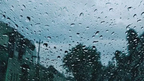 Water Drops following down on clear glass with cloudy sky Stock Footage 150415177