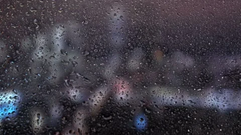 Water drops on a glass surface. Window with cityscape background. Rain drops. Stock Footage 235367135