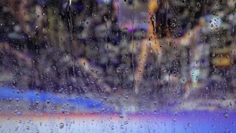 Water drops on a glass surface. Window with cityscape background. Rain drops. Stock Footage 235367137