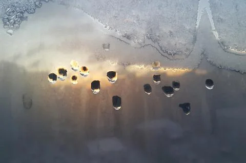 Water drops, ice pattern and sunlight on window glass 写真素材