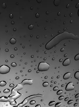 Water drops in motion through the window after rain. Stock Photos