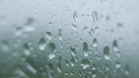 Water drops moving on glass surface during light rain with soft motion and Stock Footage 320287035