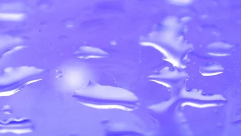 Water drops on purple window surface Stock Footage 98545640