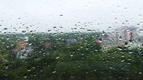 Water drops roll down the window glass during rain. Video stock 313366772