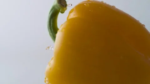 Water drops on rotating yellow pepper. Slow Motion. Stock Footage 79337015