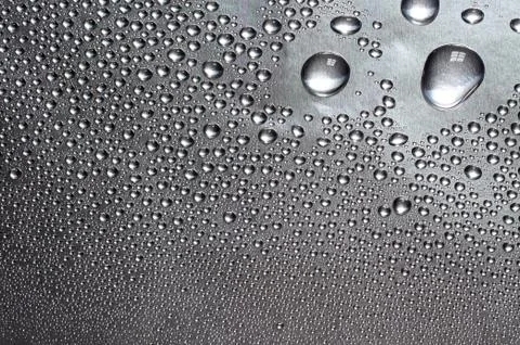 Water drops on silver surface Stock Photos