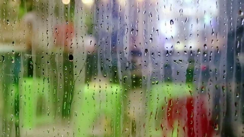Water drops sliding down on store window glass Stock Footage 70547008