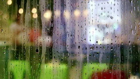 Water drops sliding down on store window glass Stock Footage 70550313
