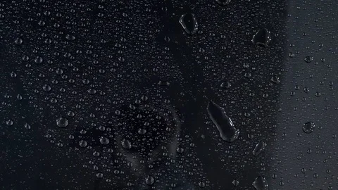 Water drops slowly flow on a black car after car wash slow motion. Stock Footage 86437352