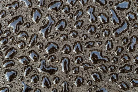 Water drops on a smooth gray surface close-up. Abstract background. Stock Photos