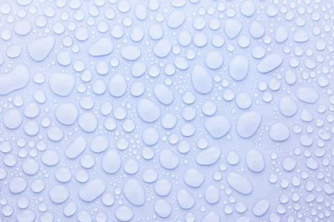 Water drops on soft light blue or violet, very peri background as elegant fre Stock Photos