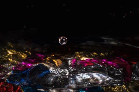 Water drops splash forming ripples and waves and abstract water columns in a Stock Photos