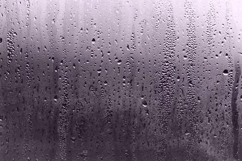 Water drops on a window in a cold, gray winter day. Stock Photos