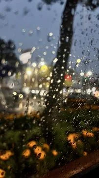 Water drops on the window with a view of night street Stock Photos