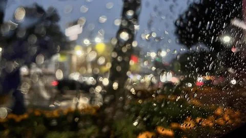 Water drops on the window with a view of night street Stock Photos