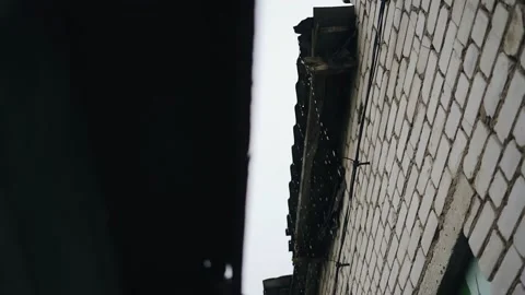Water during a downpour flows down from the roof of the garage Stock Footage 156466449