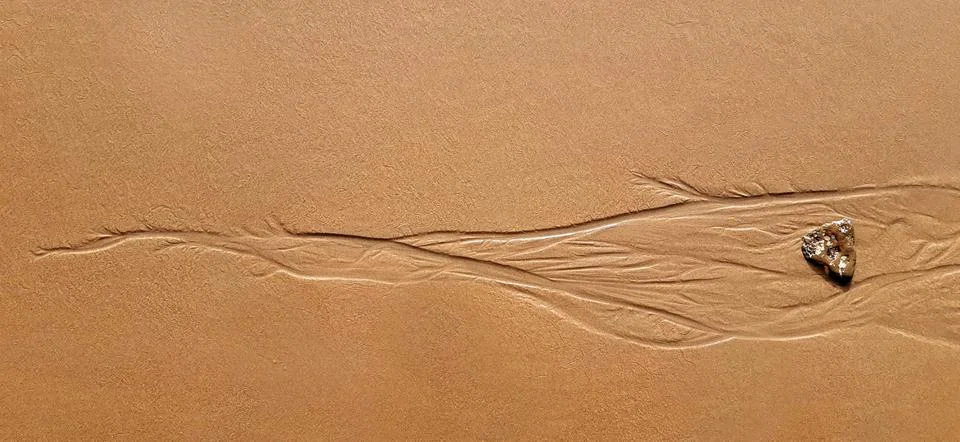 Water eroding the sand in the beach Foto stock