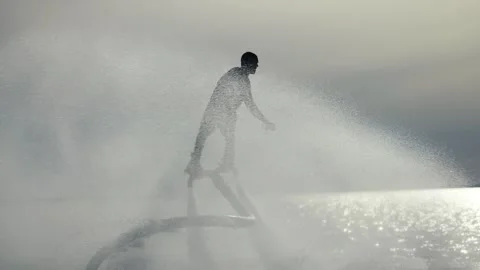 Water extreme. Flyboarder performs tricks over water. Silhouette of an Video stock 243409409