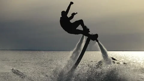 Water extreme. Flyboarder performs tricks over water. Silhouette of an Stock Footage 243409479