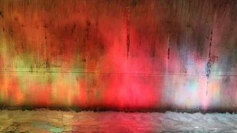 Water falling on a concrete wall on dancing colors Stock Footage 119496173