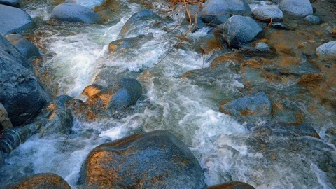 Water falling down the rocks in a mountain river. Sunset reflection. Slow motion Stock-Footage 105645862