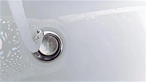 Water falling down in sink concept of hygiene and saving water Stock Footage 254776560