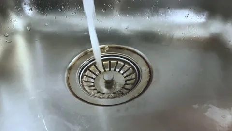 Water falling in the drain of a metallic kitchen sink Stock-Footage 160105733