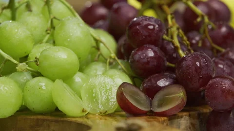 Water falling onto fresh grapes and sliced ones - closeup shot Stock Footage 341245640