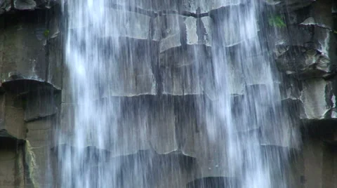 Water falling in front of hexagonal broken columns of basaltic rock Stock Footage 38020650