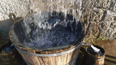 Water falling or dropping into wooden barrel and from there, through trough, Stock Footage 232352004