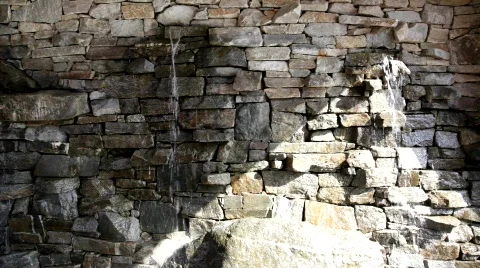 Water Falling Out of Rock Wall With Hard Angled Light Stock Footage 322903