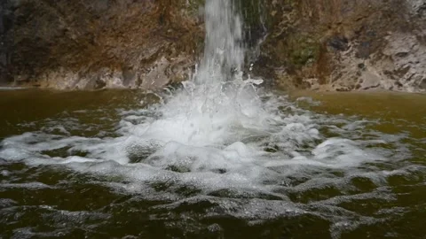 Water is falling into a pool in the mountains (slow motion) Video stock 212754633