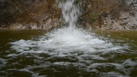Water is falling into a pool in the mountains (slow motion) Video stock 212754638