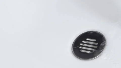 Water falling in a sink falling down the basin, on a white background Video stock 137363701