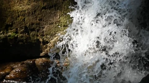 Water falling through a sunlight spot in the mountains (slow motion) Stock-Footage 219394107