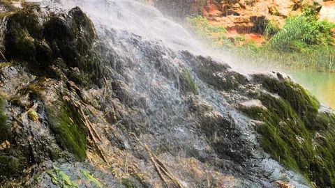 Water falling from waterfall and splashing on rock in slow motion Stock Footage 124389082