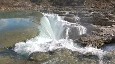 Water falls down a waterfall. Big amount of water falling over a rocky edge. Stock Footage 91513918