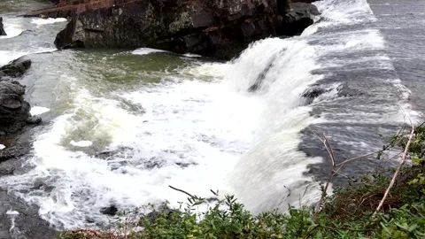 Water falls over a ledge and rushes in a rocky creek bottom, 4k Stock Footage 338193015